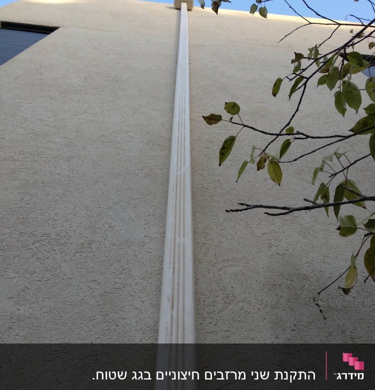 מרזב לבן מחובר לגג בניין